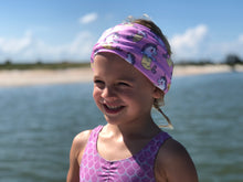 child smiling on ocean with fish scale bathing suit and unicorn mermaid neck gaiter