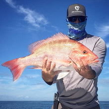 man holding red grouper fish wearing free sunshields sunglasses and waves neck gaiter mask