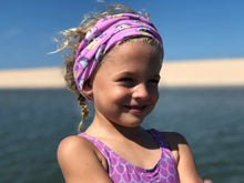 Smiling Child on ocean wearing free sunshields sunglasses and unicorn mermaid neck gaiter headband